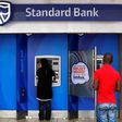 Customers queue to draw money from an ATM outside a branch of South Africa's Standard Bank in Cape Town, March 15, 2016. REUTERS/Mike Hutchings