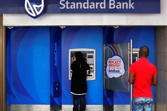 Customers queue to draw money from an ATM outside a branch of South Africa's Standard Bank in Cape Town, March 15, 2016. REUTERS/Mike Hutchings