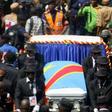 A general view taken through a window shows mourners escorting the casket of legendary Congolese singer Papa Wemba, born Jules Shungu Wembadio Pene Kikumba, from the the Notre Dame du Congo Cathedral for burial, along the streets of the Democratic Repu...