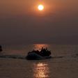 Refugees and migrants wave as they approach the shores of the Greek island of Lesbos on a dinghy during sunrise, March 20, 2016. REUTERS/Alkis Konstantinidis