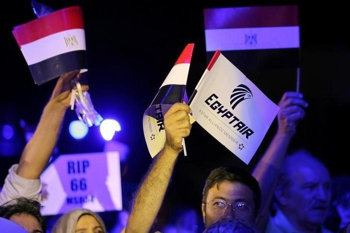 People hold EgyptAir flags during a candlelight vigil for the victims of EgyptAir flight 804, at the Cairo Opera House in Cairo, Egypt May 26, 2016.