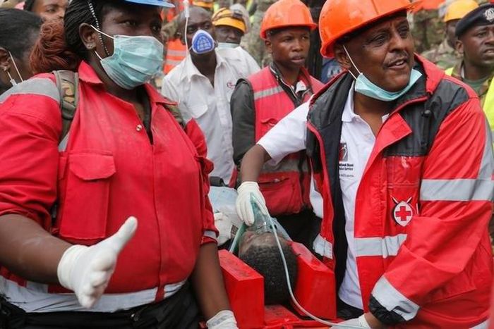 Kenya Red Cross rescuers evacuate a woman from the rubble of a six-storey building that collapsed last Friday after days of heavy rain, in Nairobi, Kenya May 5, 2016.