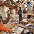 Soldiers and policemen are pictured at the scene where two female suicide bombers blew themselves up at a mobile phone market in the northern Nigerian city of Kano November 18, 2015. The explosions occurred at the Farm Centre phone market, near the cen...