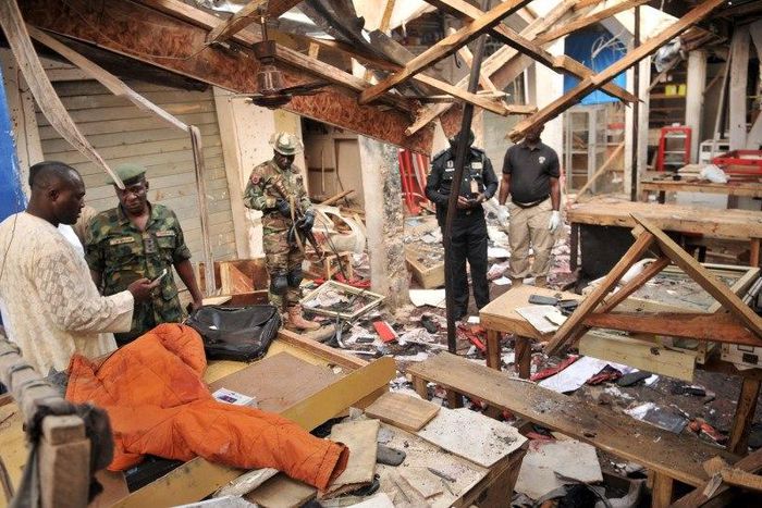 Soldiers and policemen are pictured at the scene where two female suicide bombers blew themselves up at a mobile phone market in the northern Nigerian city of Kano November 18, 2015. The explosions occurred at the Farm Centre phone market, near the cen...