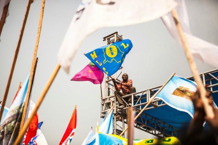 A demonstrator waves a party's flag of the Movement for the Liberation of the Congo (MLC), during a rally in support of Congolese President Joseph Kabila in Kinshasa, on July 29, 2016