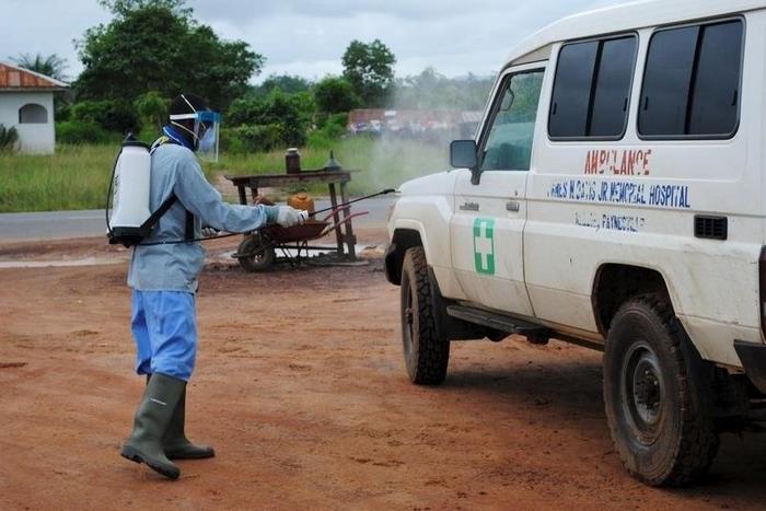 A health worker sprays disinfectant on an ambulance in Nedowein, Liberia, July 15, 2015.