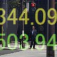A businessman is reflected in an electronic board displaying Japan's Nikkei share average outside a brokerage in Tokyo, Japan, April 18, 2016.