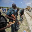 Somali soldiers secure a partially-crumbled perimeter wall following twin car bombings outside UN buildings in Mogadishu on July 26
