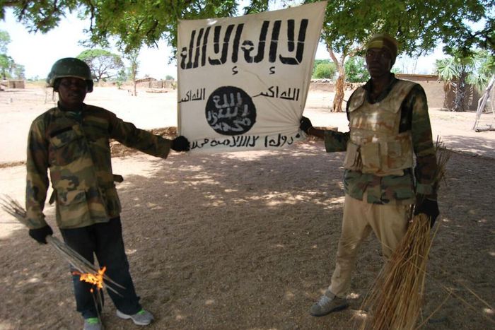 Some soldiers displaying Boko Haram flag after capturing their camps in Sambisa Forest.