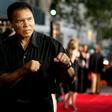 Boxing legend Muhammad Ali (R) jabs at photographers while arriving at the Orpheum Theatre for the premiere of the film "Collateral" in Los Angeles in this August 2, 2004 file photo. REUTERS/Robert Galbraith/File Photo