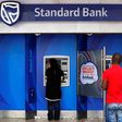 Customers queue to draw money from an ATM outside a branch of South Africa's Standard Bank in Cape Town, March 15, 2016. REUTERS/Mike Hutchings