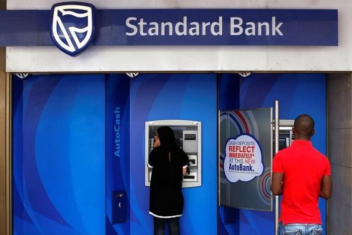 Customers queue to draw money from an ATM outside a branch of South Africa's Standard Bank in Cape Town, March 15, 2016. REUTERS/Mike Hutchings