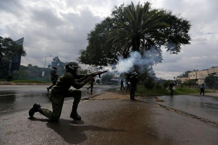 A riot policeman lobs a teargas canister to disperse supporters of the opposition Coalition for Reforms and Democracy (CORD), during a protest at the premises hosting the headquarters of Independent Electoral and Boundaries Commission (IEBC) to demand ...