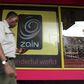 A man uses his mobile phone as he walks past a Zain customer care shop in Nairobi February 15, 2010.  REUTERS/Thomas Mukoya