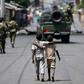 Boys walk behind patrolling soldiers in Bujumbura, Burundi, May 15, 2015. REUTERS/Goran Tomasevic/Files