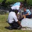 File picture shows French gendarmes and police inspecting a large piece of plane debris which was found on the beach in Saint-Andre, on the French Indian Ocean island of La Reunion, July 29, 2015.