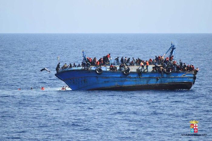 Migrants are seen on a capsizing boat before a rescue operation by Italian navy ships "Bettica" and "Bergamini" (unseen) off the coast of Libya in this handout picture released by the Italian Marina Militare on May 25, 2016.