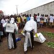 Healthcare workers prepare to remove the body of a man suspected of carrying Ebola in Monrovia, Liberia, July 17, 2015. REUTERS/James Giahyue
