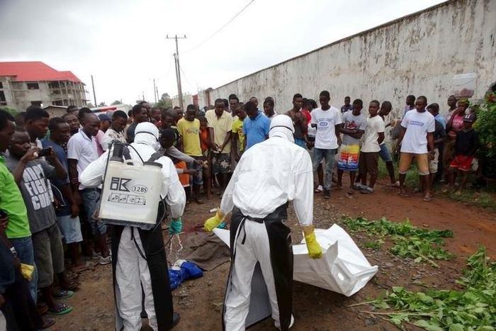 Healthcare workers prepare to remove the body of a man suspected of carrying Ebola in Monrovia, Liberia, July 17, 2015. REUTERS/James Giahyue