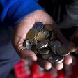 A street trader counts out change for a customer in Durban, September 8, 2015. REUTERS/Rogan Ward