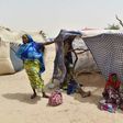 This photo taken on June 19, 2016 in the village of Kidjendi near Diffa shows women standing near makeshift tent in a camp as displaced families fled from Boko Haram attacks in Bosso