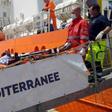 A migrant receives help when disembarking from the SOS Mediterranee ship Aquarius at the Italian island of Lampedusa in this handout received April 18, 2016.
