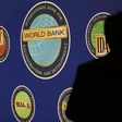 A man is silhouetted against the logo of the World Bank at the main venue for the International Monetary Fund (IMF) and World Bank annual meeting in Tokyo October 10, 2012.  REUTERS/Kim Kyung-Hoon