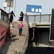 People walk past a sign of French telecom operator Orange hanging from a bridge in Cairo, Egypt March 13, 2016.