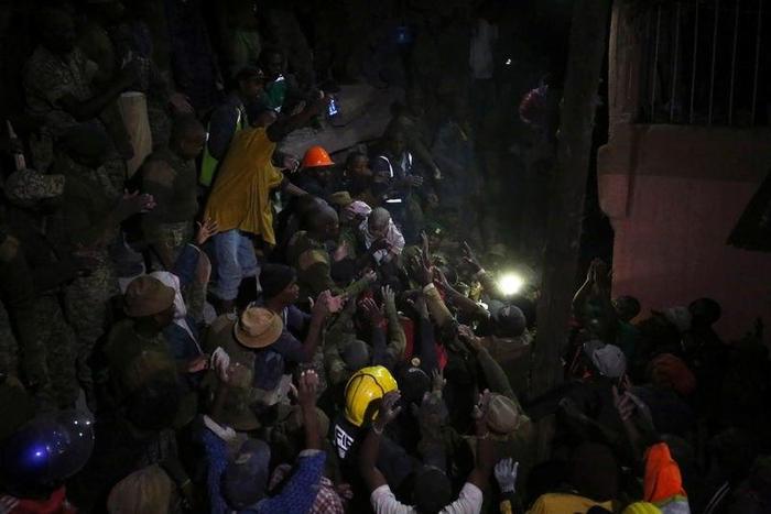 Volunteers evacuate a child rescued from the rubble of a six-storey building that collapsed after days of heavy rain, in Nairobi, Kenya April 30, 2016.