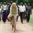 Zimbabwean commercial farmer Tommy Bayley rides an old bicycle ahead of war veterans and villagers, who invaded his farm at Danbury Park outside the capital