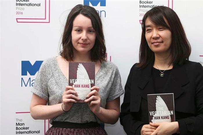 Han Kang (R) and translator Deborah Smith as they pose for a photograph with the book 'The Vegetarian'.