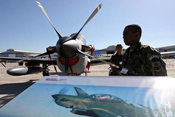 A Brazilian soldier stands guard near a A-29 Super Tucano during the opening ceremony of the Santiago's Aviation Fair, known as FIDAE, at Chile's international airport, file.