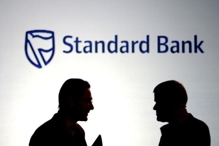 Businessmen chat in front of a Standard Bank logo in Sandton outside Johannesburg,  file. 

       REUTERS/Siphiwe Sibeko