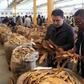 Buyers check the quality of tobacco during the last day of the selling season at Tobacco Sales Floor (TSF) in Harare, July 15, 2015. REUTERS/Philimon Bulawayo