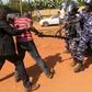 A supporter of Uganda's former Prime Minister Amama Mbabazi wrestles with the gun of a policeman, as riot police disperse a gathering in Jinja town in eastern Uganda September 10, 2015.  REUTERS/James Akena