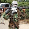 A member of Somalia's hardline al Shabaab rebel group walks with a machine gun after attending Eid al-Adha prayers inside a football stadium north of the capital Mogadishu November 16, 2010. REUTERS/Feisal Omar
