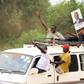 A supporter of Amama Mbabazi, former Ugandan prime minister and presidential candidate for The Democratic Alliance (TDA), holds a poster of him atop a mini bus during a campaign rally ahead of the February 18 presidential election, in Lyantonde town, U...