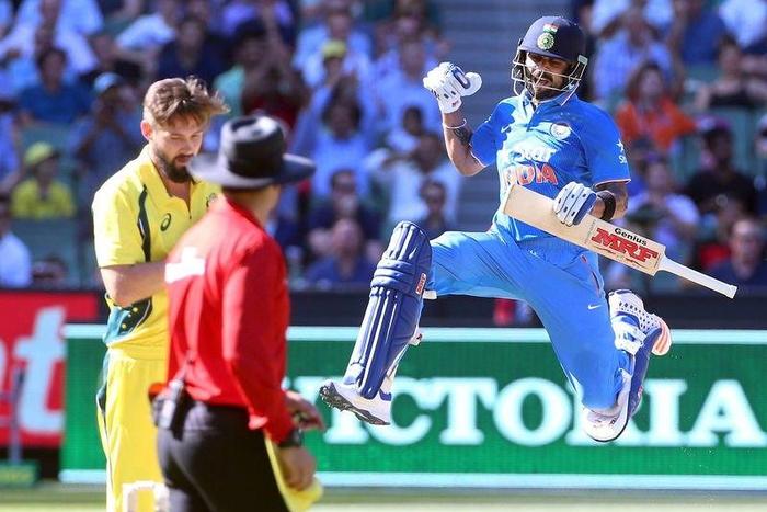 India's Virat Kohli celebrates his century with Australia's Kane Richardson (L) watching during their One Day cricket match at the Melbourne Cricket Ground, January 17, 2016. REUTERS/Hamish Blair