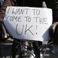 A migrant holds a placard which reads "I want to come to the U.K." on his bicycle at the makeshift camp called "The New Jungle" in Calais, France, September 19, 2015. REUTERS/ Regis Duvignau