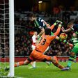 Swansea City captai, Ashley Williams bundles the ball past Arsenal goalkeeper, Petr Cech to score the winner