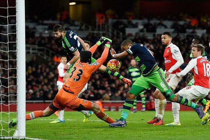 Swansea City captai, Ashley Williams bundles the ball past Arsenal goalkeeper, Petr Cech to score the winner