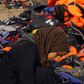 A Syrian refugee rests by a pile of life jackets after arriving in an overcrowded raft at a beach on the Greek island of Lesbos October 19, 2015. REUTERS/Yannis Behrakis