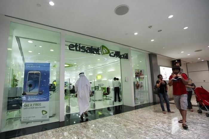 Customers walk past an Etisalat store at a shopping mall in Dubai, July 10, 2012.  REUTERS/Jumana El Heloueh