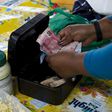 An informal trader counts out change in her cash box at her stall in Hillcrest, west of Durban, South Africa, January 11, 2016. REUTERS/Rogan Ward