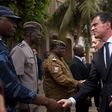 French Prime Minister Manuel Valls shakes hands with head of rapid intervention unit Commander Evrard Somda in front of Cappuccino cafe, the site of an Al Qaeda attack that killed 30 in January in Ouagadougou, Burkina Faso, February 20, 2016. REUTERS/N...