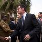 French Prime Minister Manuel Valls shakes hands with head of rapid intervention unit Commander Evrard Somda in front of Cappuccino cafe, the site of an Al Qaeda attack that killed 30 in January in Ouagadougou, Burkina Faso, February 20, 2016. REUTERS/N...