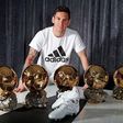 Lionel Messi poses with his five Ballon d'Or and the adidas platinum boots