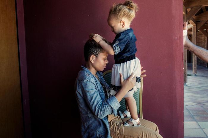 Jasmine plays with the hair of her mother, Shalom.