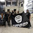 Iraqi security forces hold an Islamist State flag which they pulled down at the University of Anbar, in Anbar province July 26, 2015. REUTERS/Stringer