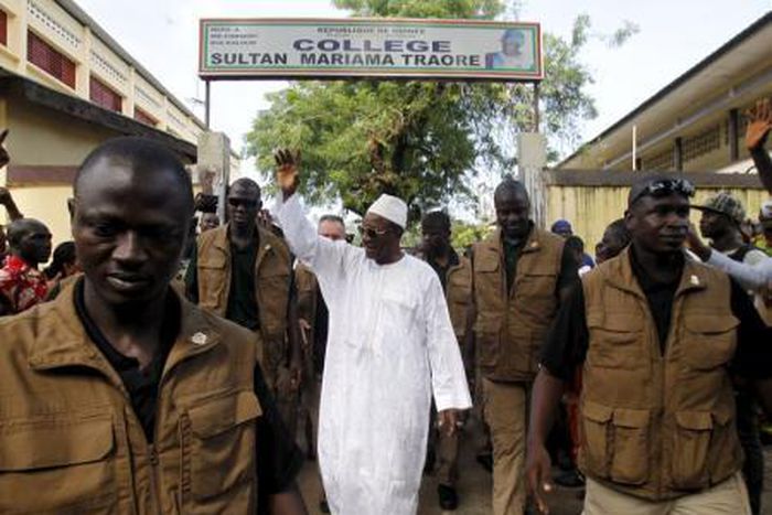 Incumbent president Alpha Conde, leader of Rassemblement du Peuple de Guinea (RPG), wavess as he leaves the polling station during a presidential election in Conakry, Guinea October 11, 2015.